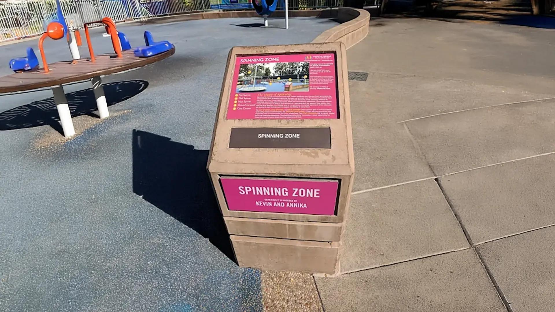 Outdoor donor recognition sign at an inclusive playground highlighting a spinning play zone for children of all abilities.