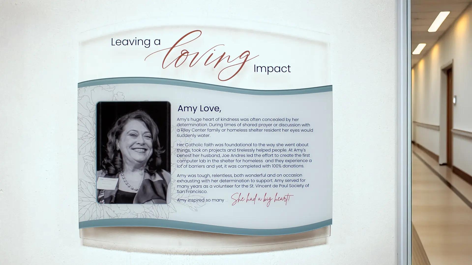 Memorial donor recognition wall honoring Amy Love and her service to the St. Vincent de Paul Society in a healthcare corridor.