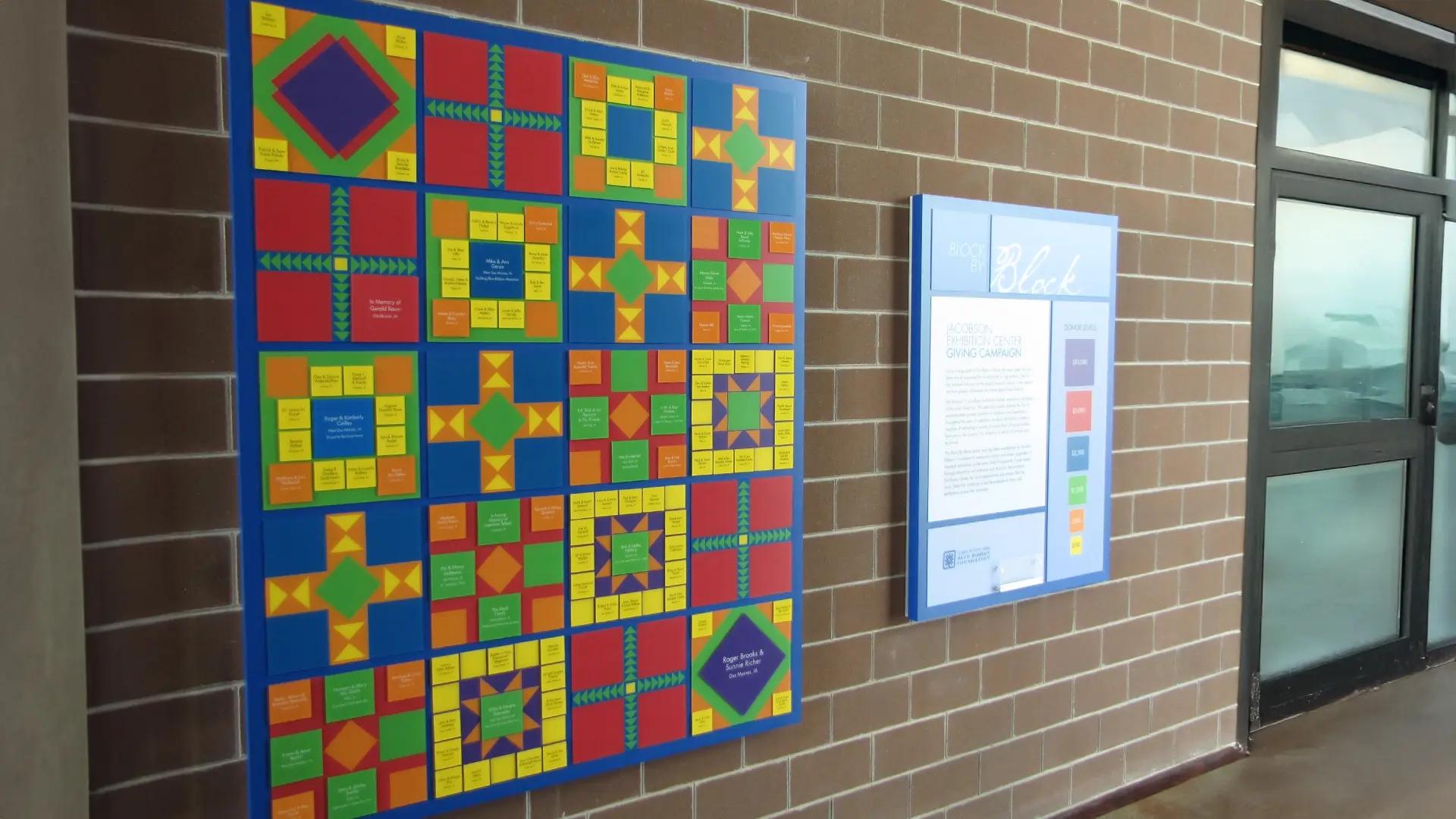 Colorful donor recognition wall with geometric quilt design featuring updateable donor tiles for the Iowa State Fair Blue Ribbon Foundation.