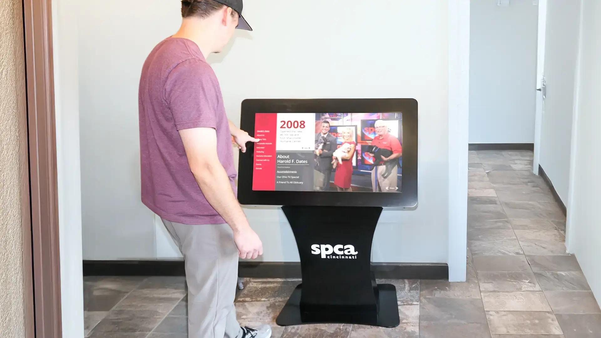 Interactive donor recognition touchscreen kiosk for SPCA Cincinnati displaying donor stories and timelines in a custom freestanding digital kiosk.