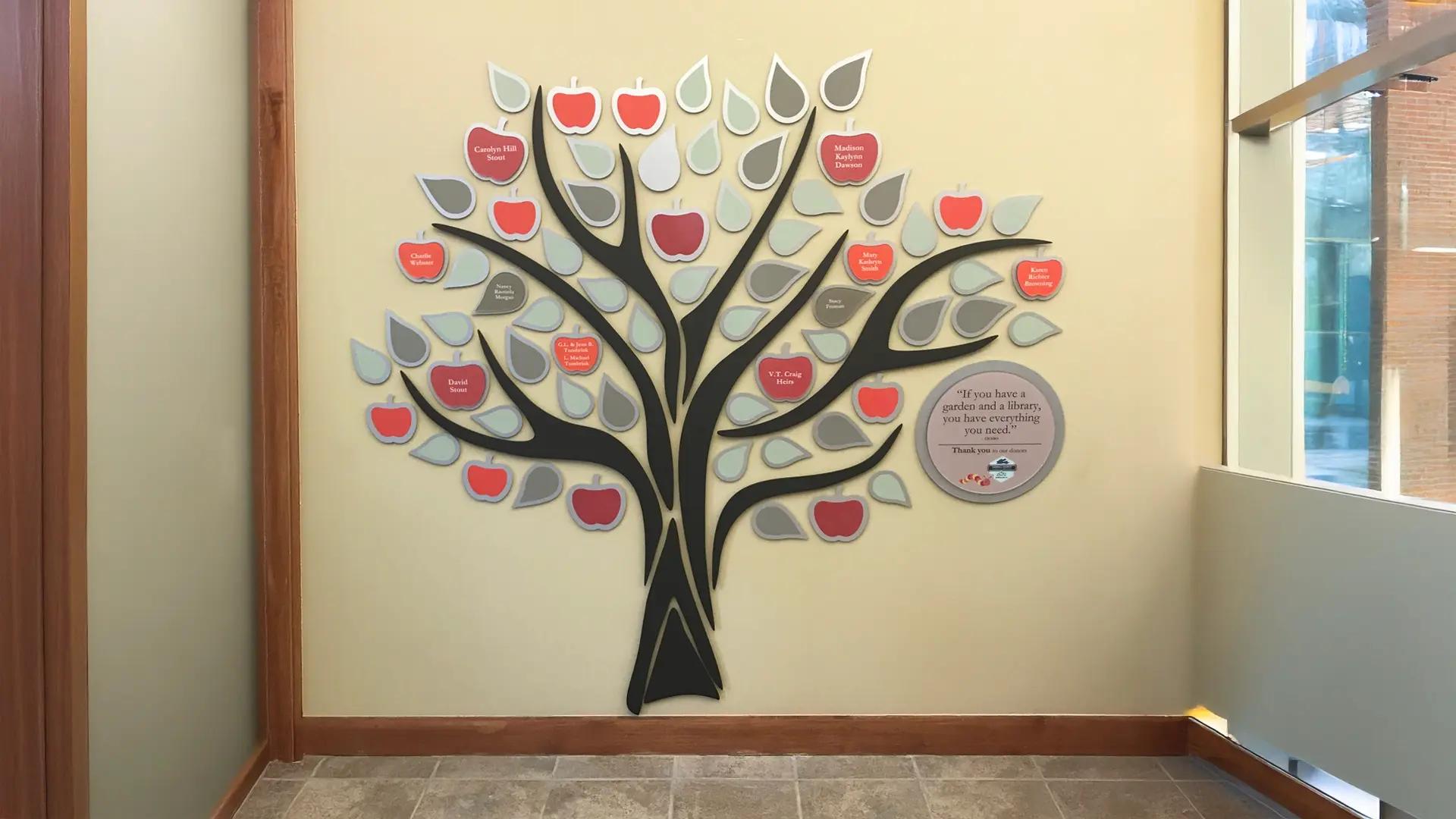 Carroll County Library donor wall featuring a tree design with apple and leaf donor plaques recognizing community supporters.