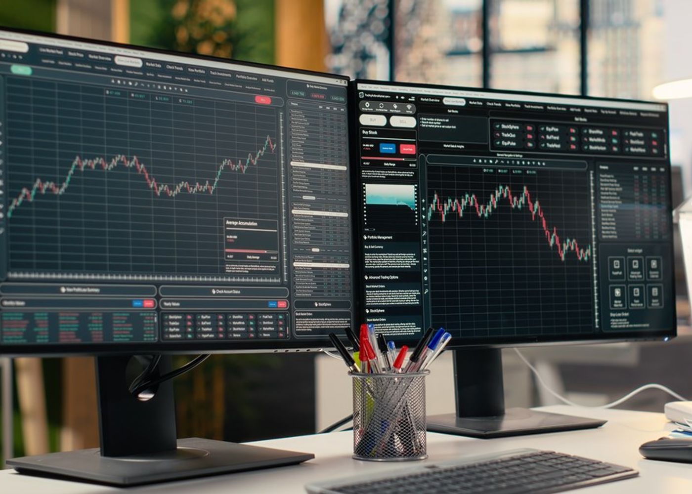 Two trading monitors showing stock charts on a desk, illustrating the stock market ahead of the October 28, 2026 Fed decision