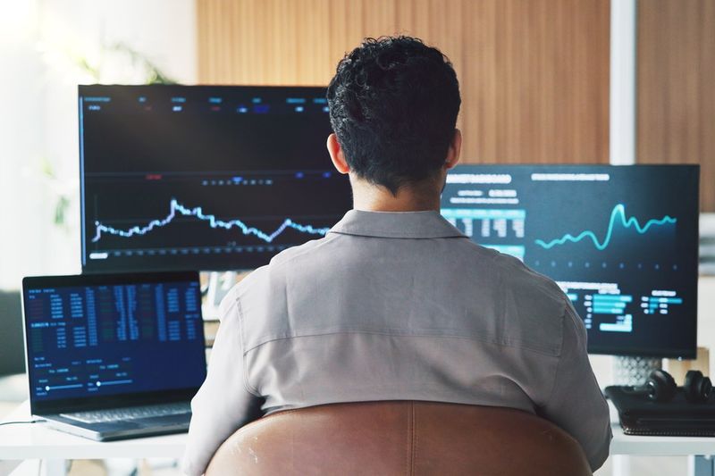 Trader watching stock charts on three monitors, illustrating options expiration Friday on October 16, 2026