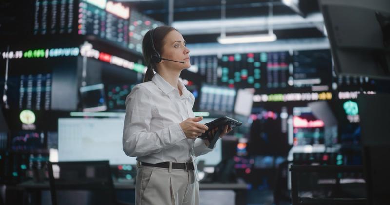 Analyst with a headset watching a wall of market screens ahead of the October 2026 Fed rate decision
