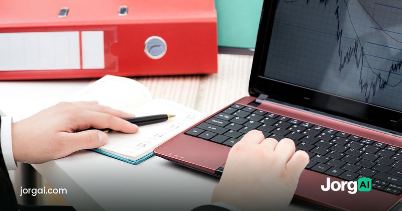 Hands at a laptop showing a stock chart beside a planner, cover for the turn-of-the-month effect study