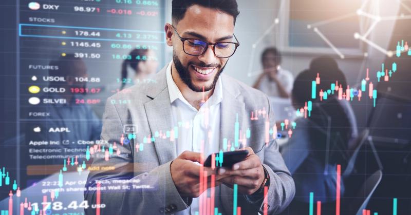 Trader smiling at phone with market charts overlay, representing API-friendly brokerage automation