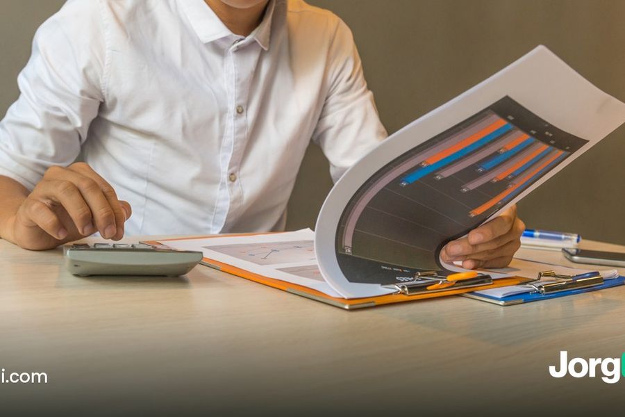 Accountant checking a fee statement with a calculator and a chart, cover for the broker pricing comparison for automated trading