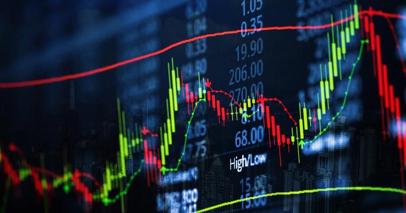 Close-up of red and green candlesticks with moving average lines and price figures on a dark trading screen