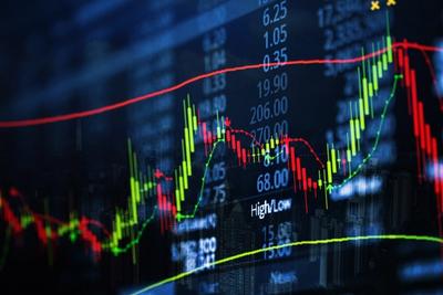 Close-up of red and green candlesticks with moving average lines and price figures on a dark trading screen