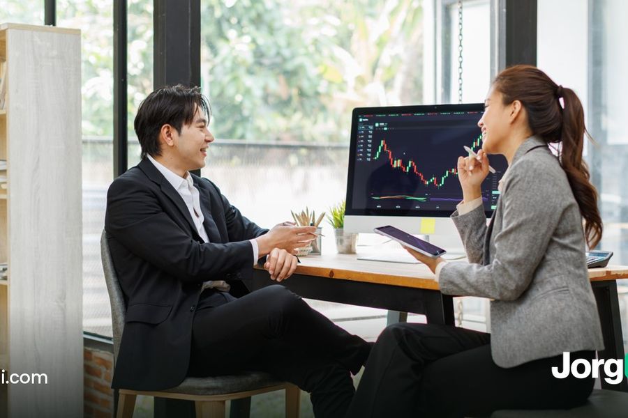 Two people reviewing figures at a meeting table, cover for the Oracle and CoreWeave AI debt selloff post