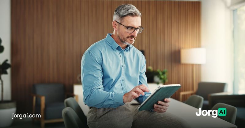 Investor comparing options on a tablet in an office, cover for the JorgAI vs TradersPost cost comparison