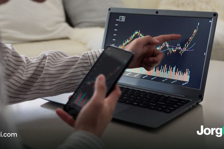 Person checking a stock chart on a laptop and phone at home, cover for the cash account versus margin account guide