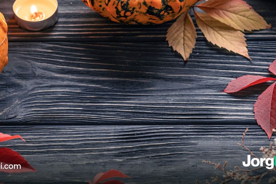 Autumn table with pumpkins, red leaves and a candle on dark wood, Thanksgiving week