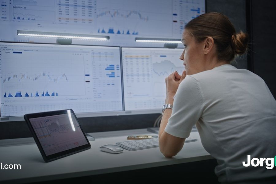 Trader reviewing charts on two monitors with a tablet, cover for the Kraken trading bots guide