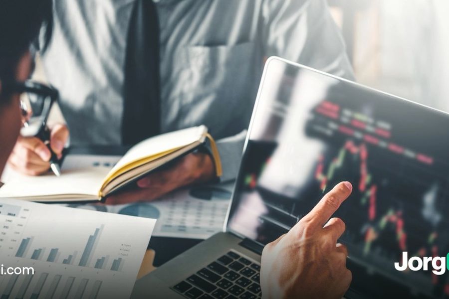 Two analysts reviewing printed charts and a laptop price chart ahead of the September 2026 ISM Services PMI report