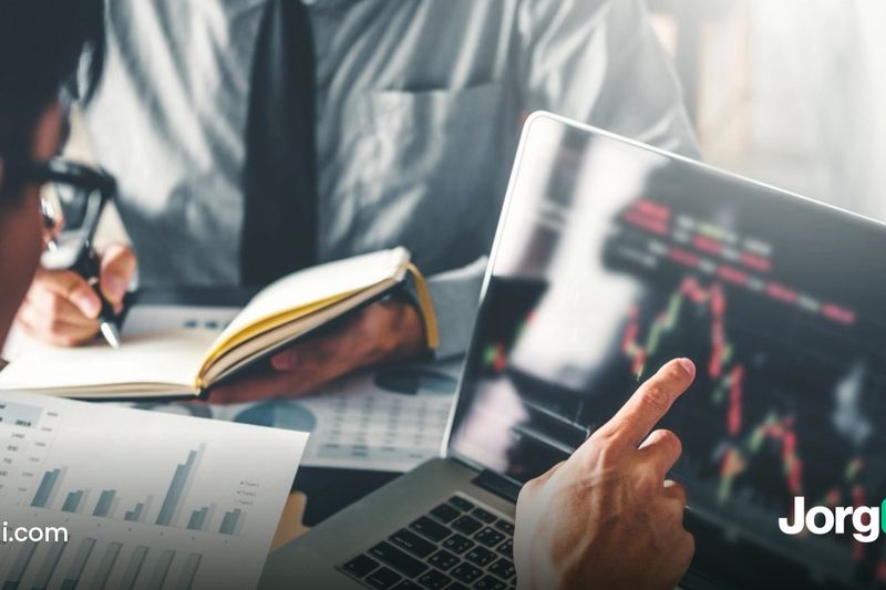 Two analysts reviewing printed charts and a laptop price chart ahead of the September 2026 ISM Services PMI report