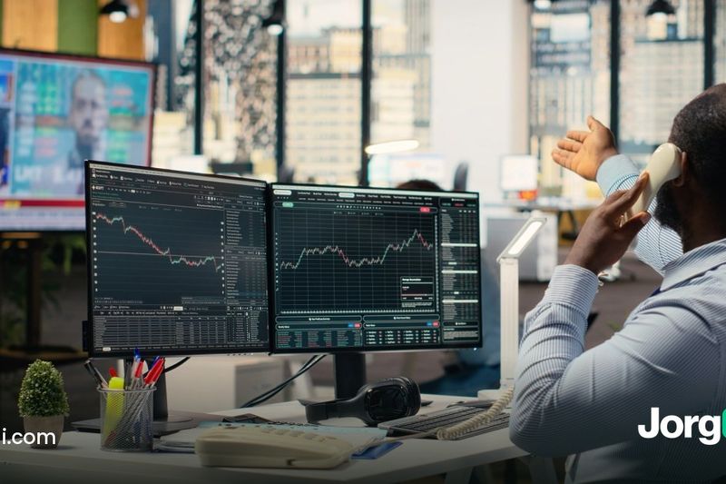 Trader on the phone at a desk with market charts and financial news on screen, the morning stocks rallied on the weak September 2026 jobs report