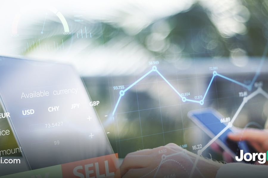 Hands using a laptop and a phone showing a trading chart with buy and sell buttons, cover for the Crypto.com Exchange vs App explainer