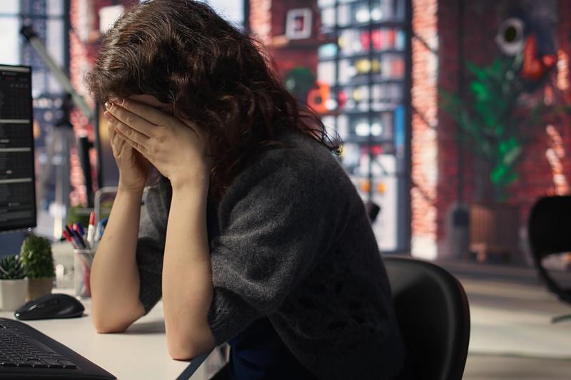 Frustrated trader at a desk of red charts after a losing session