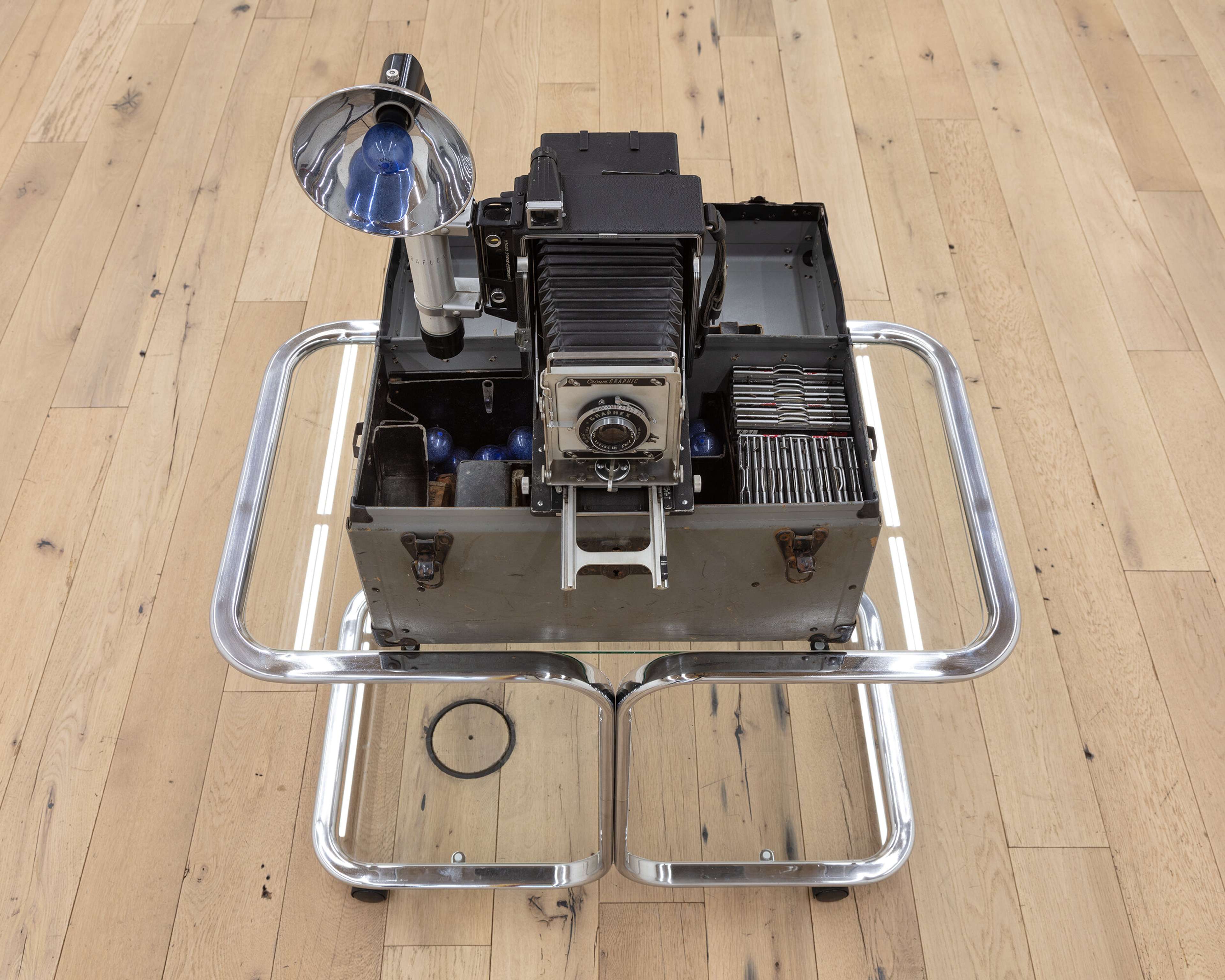 Kayode Ojo, where did all the money go?, 2020, Milo Baughman–style two-tier chrome bar cart, Graflex Crown Graphic police camera kit, 51 × 33 × 20 1⁄2″.
