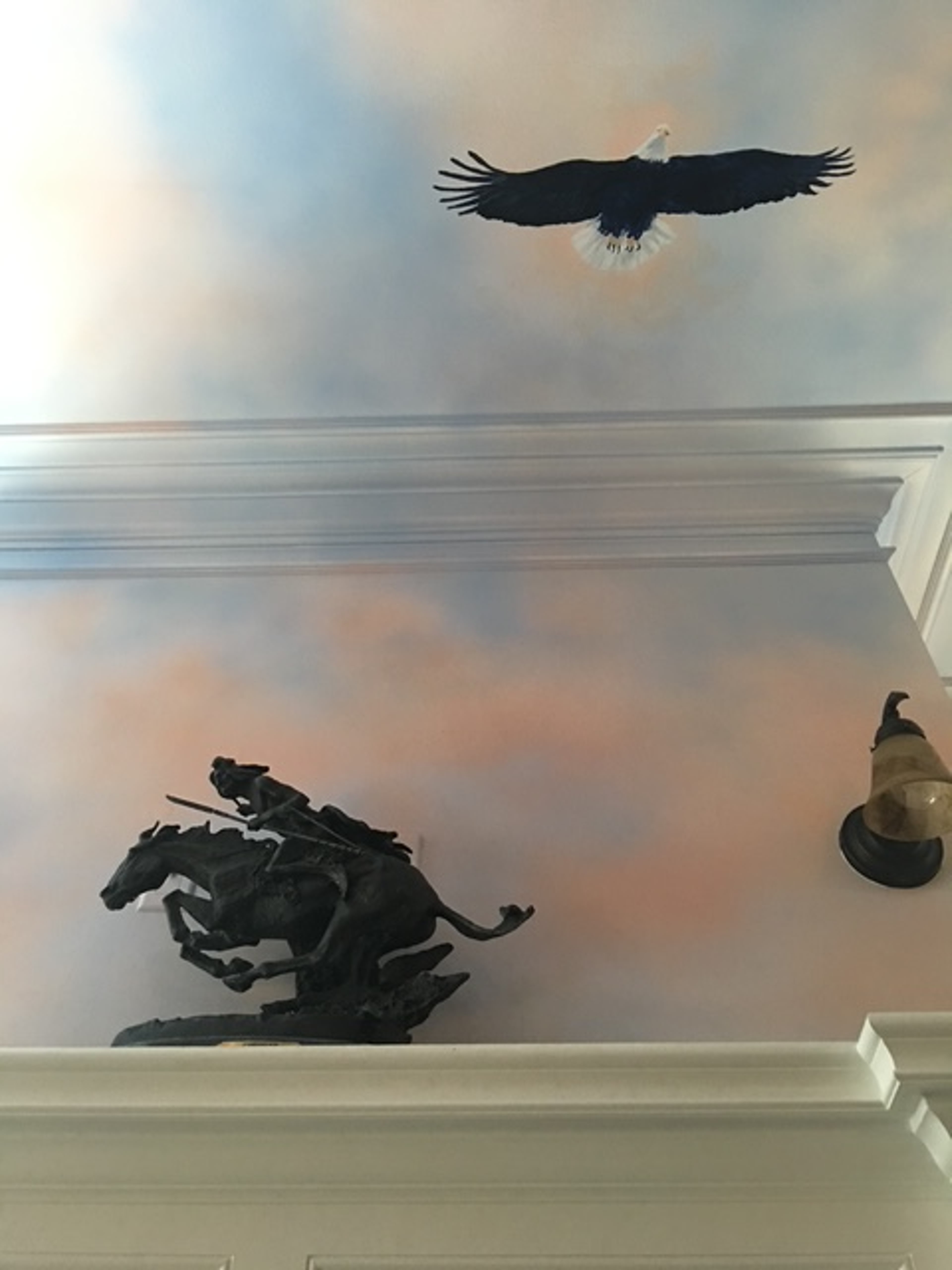 Hand-painted ceiling mural with trompe l'oeil bald eagle and sunset sky in Early American themed law firm
