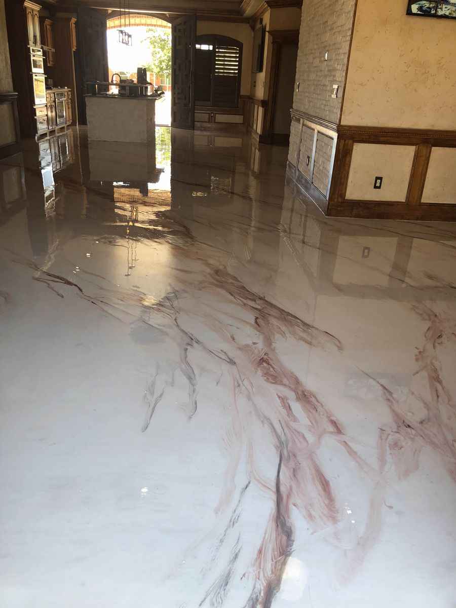 Metallic epoxy faux marble floor in great room with cream base, burgundy veining, and mirror-gloss reflective finish.
