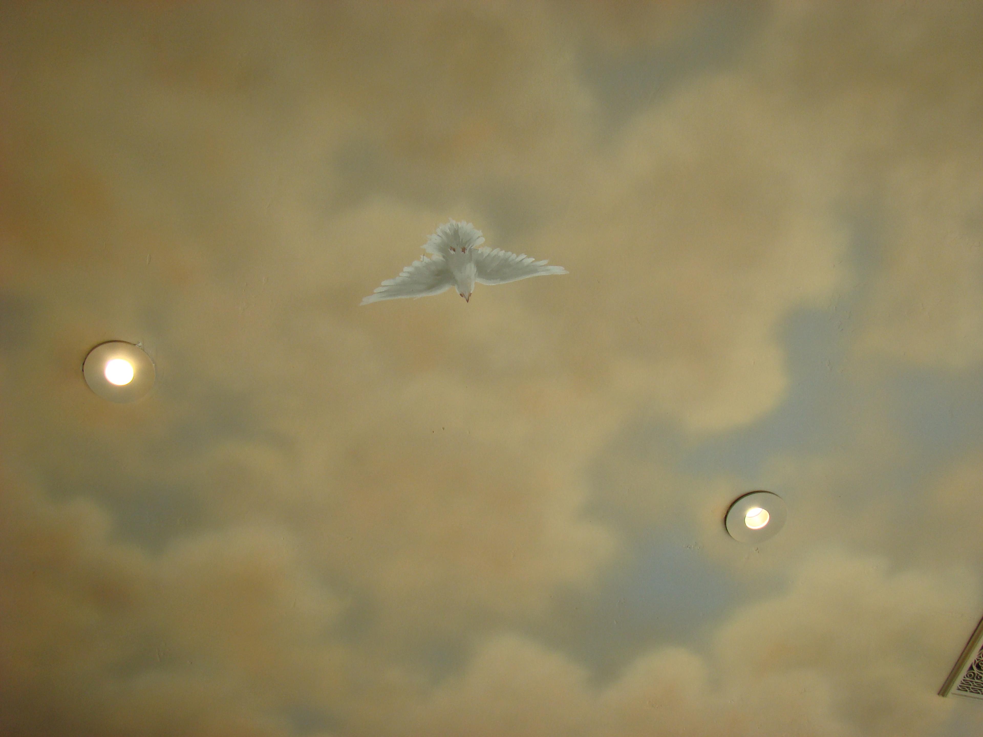 Hand-painted trompe l'oeil ceiling mural featuring a white dove in flight among warm golden clouds, Houston decorative finish