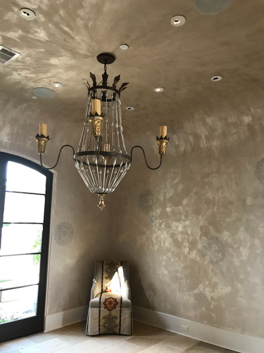 Pearlescent Venetian plaster foyer with metallic mottling, tone-on-tone stencil medallions, and crystal chandelier — Houston luxury finish
