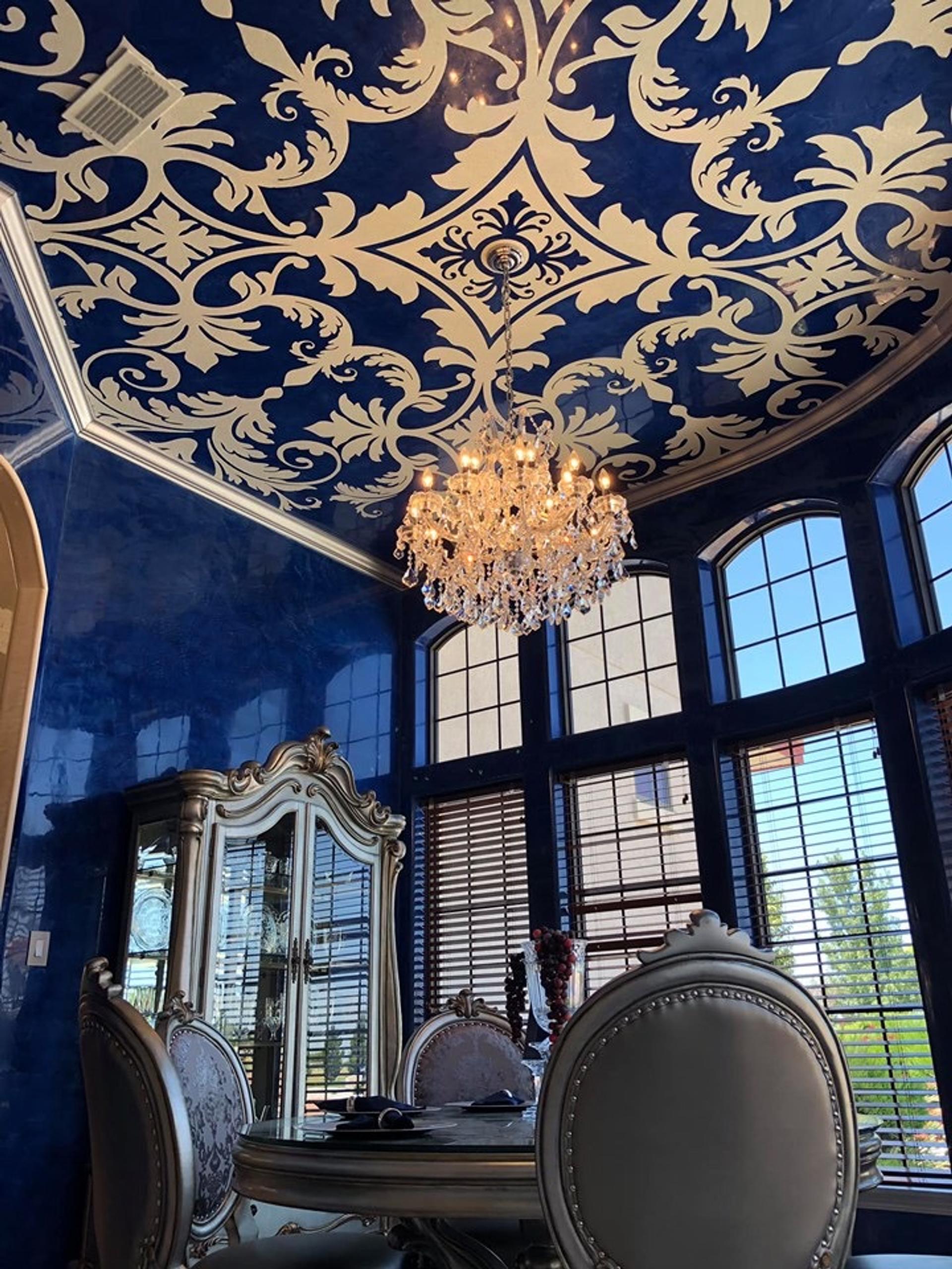 High-gloss cobalt Venetian plaster dining room with gold damask stenciled ceiling and crystal chandelier, Houston luxury interior.