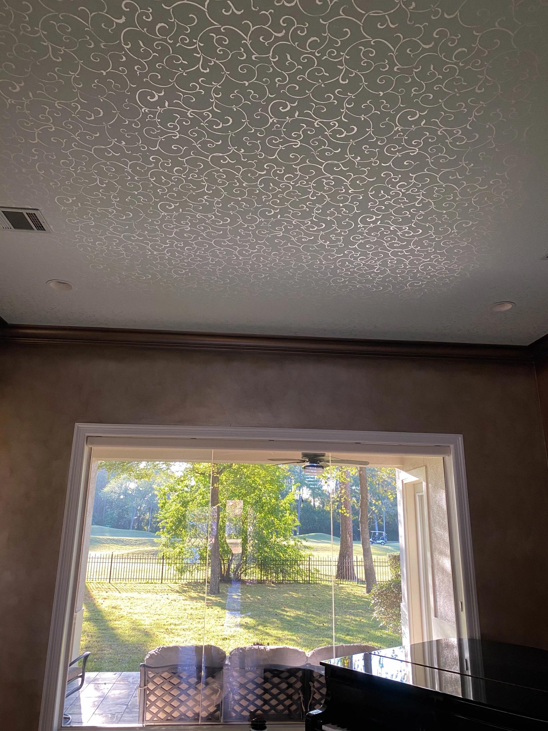 Pearlescent modello scrollwork stencil covering entire great room ceiling above Venetian plaster walls, Houston luxury home.