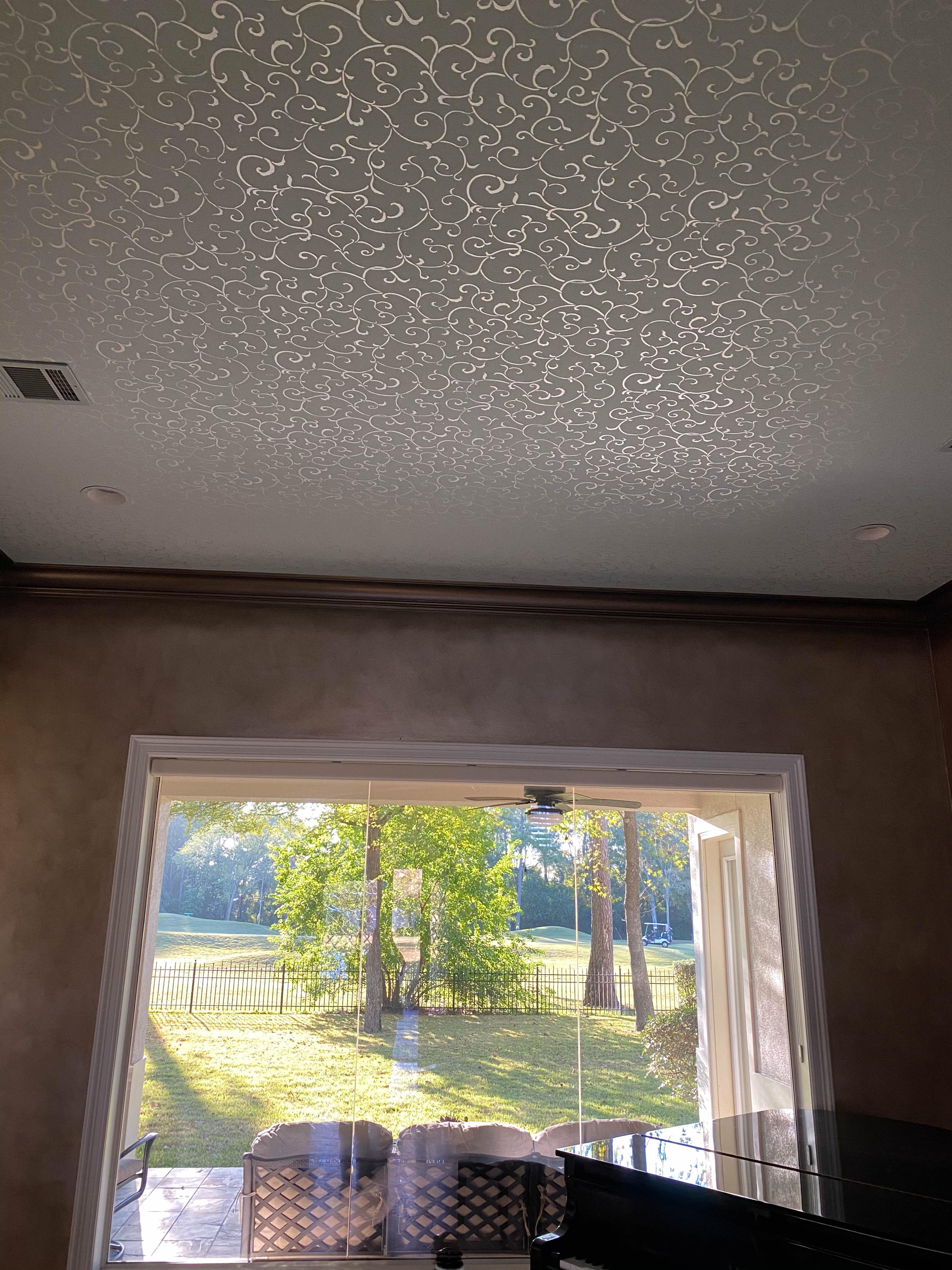 Pearlescent modello scrollwork stencil covering entire great room ceiling above Venetian plaster walls, Houston luxury home.