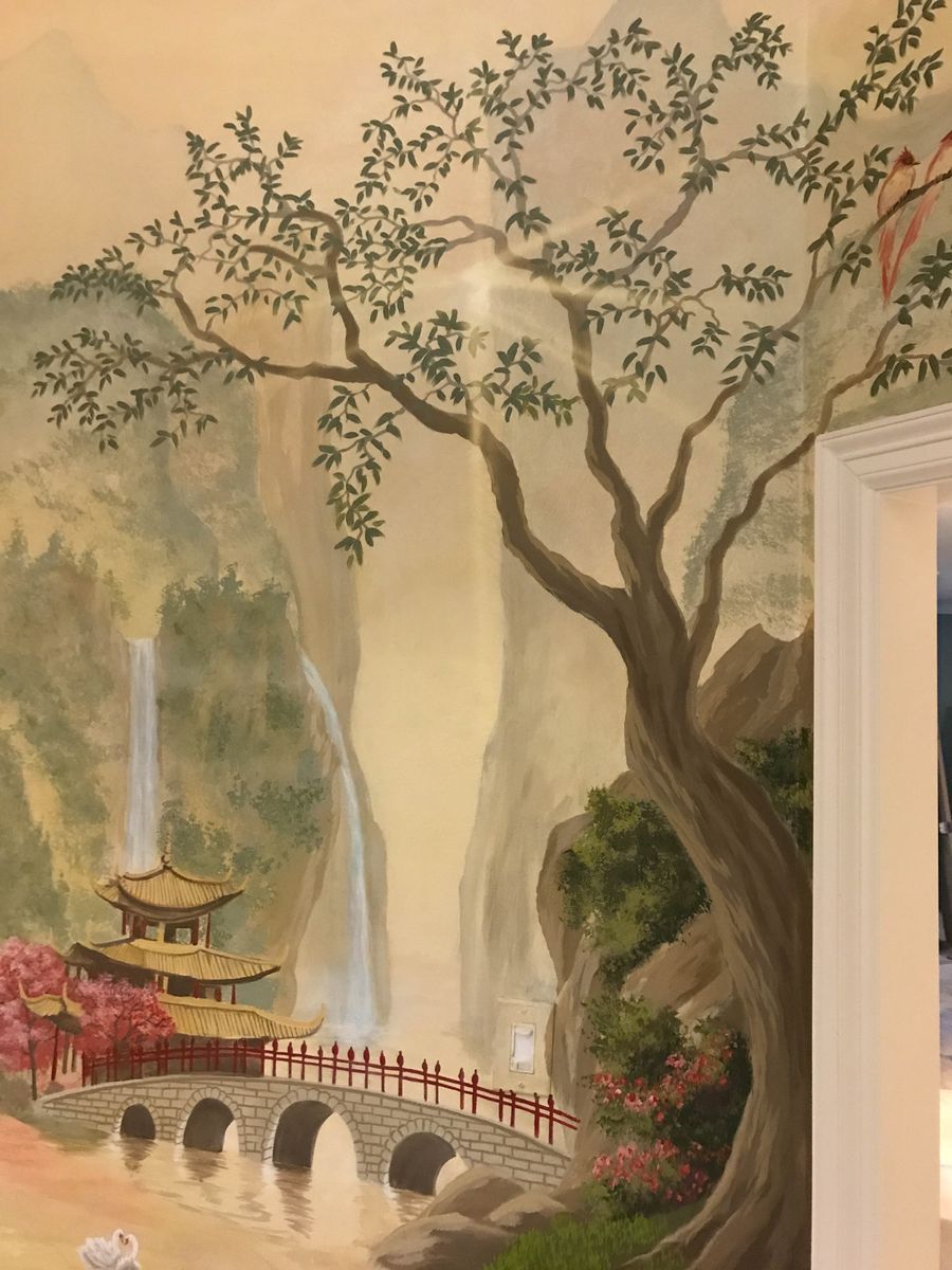 Chinoiserie hand-painted wall mural with gnarled tree, gold pagoda, stone bridge, and cascading waterfall in warm tones.