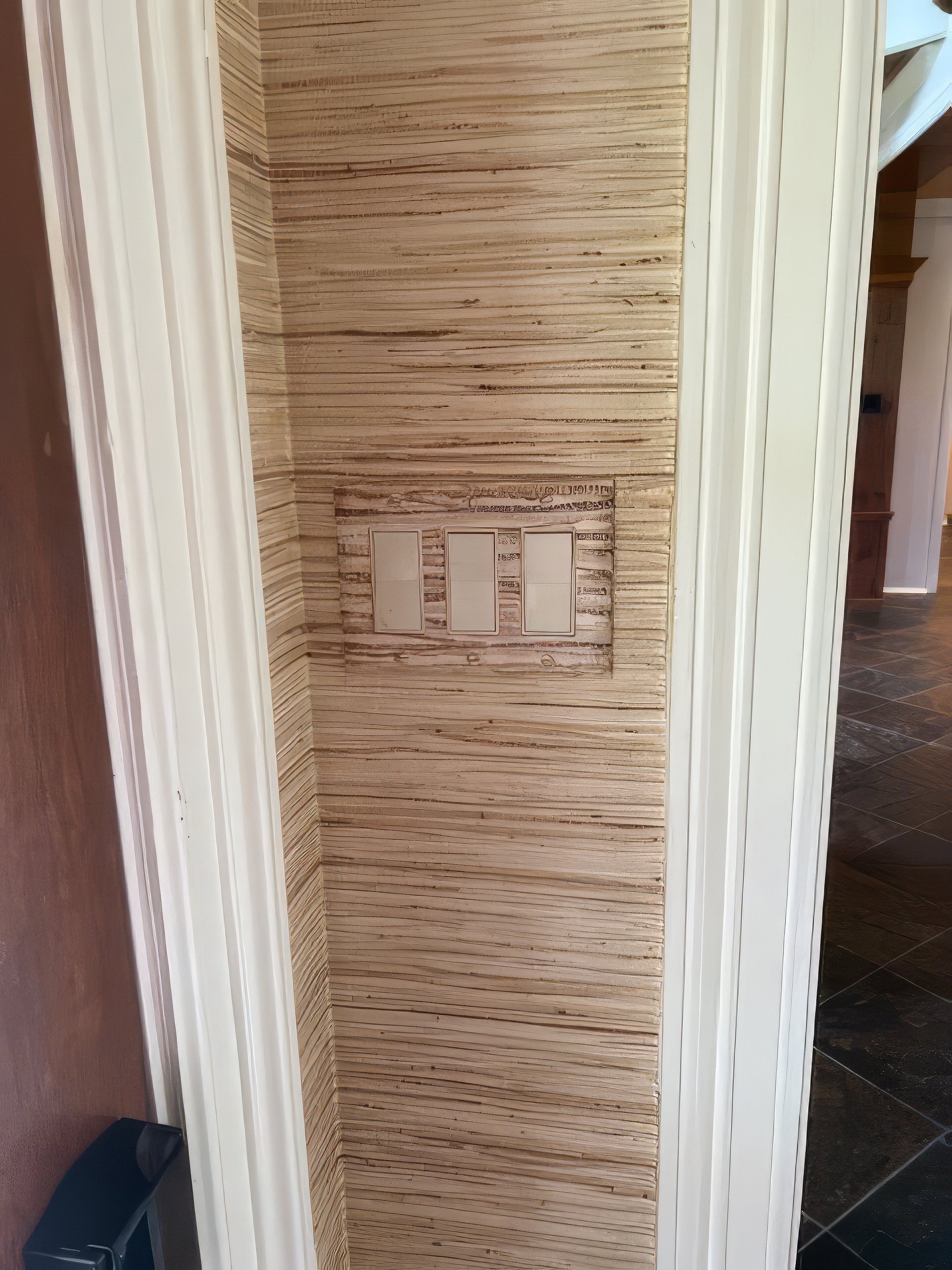 Grasscloth faux finish in warm straw tones in residential hallway with integrated double light switch plate, Houston.