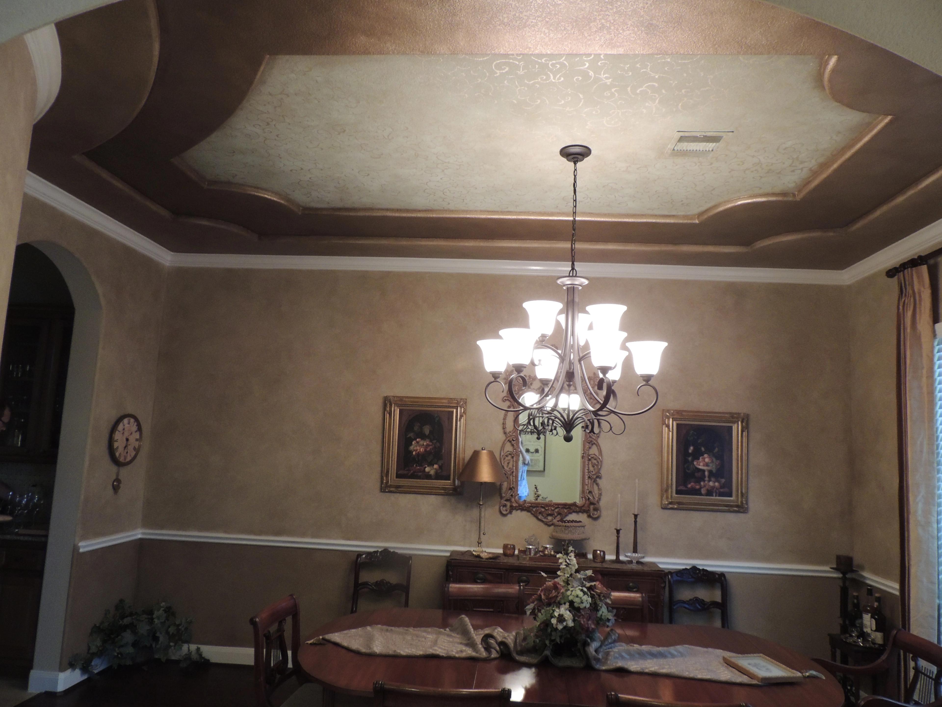 Formal dining room with bronze metallic tray ceiling, scroll stencil detail, and aged parchment Venetian plaster walls in Hou