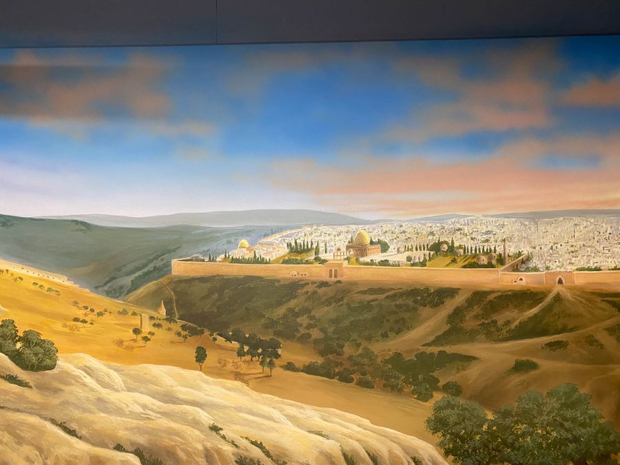 Hand-painted panoramic Jerusalem mural with Dome of the Rock, golden hillside foreground, and atmospheric sunset sky.