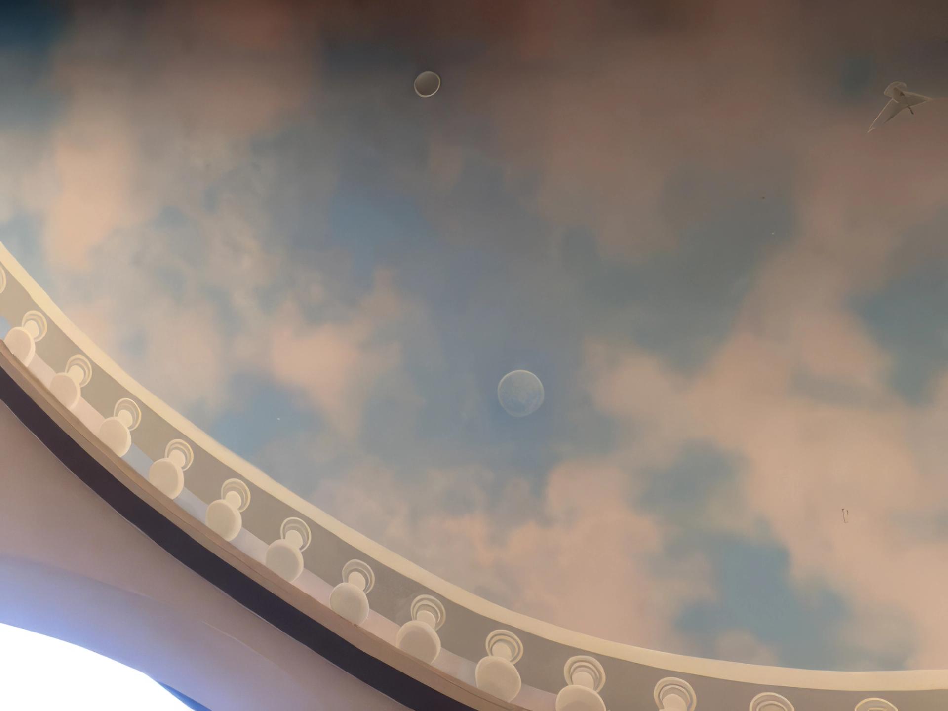 Airbrushed sky ceiling mural with clouds and moon on curved vault with white dentil molding, residential.