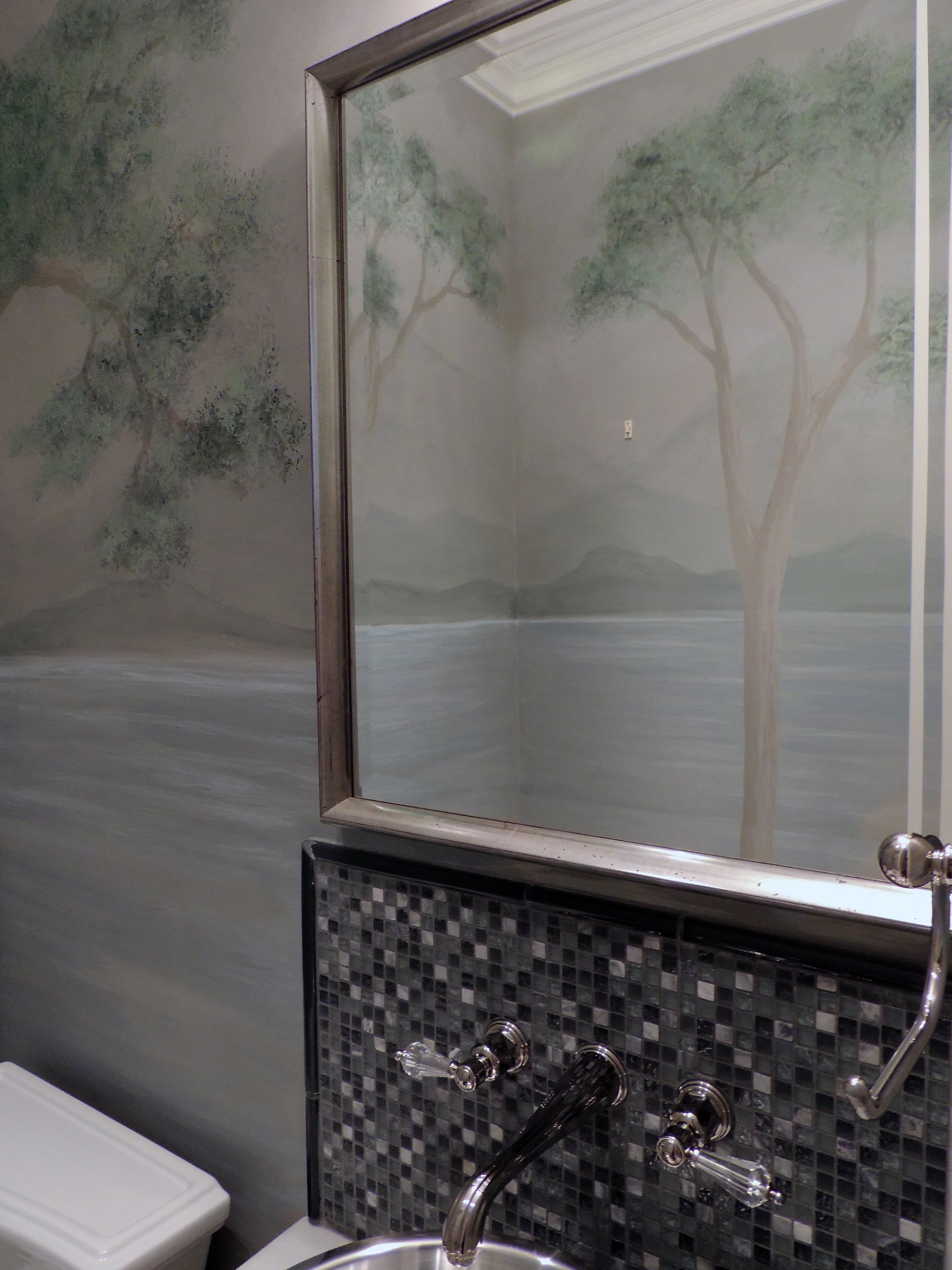 Hand-painted botanical tree mural in sage and taupe tones adorning bathroom walls alongside grey glass mosaic tile and polish
