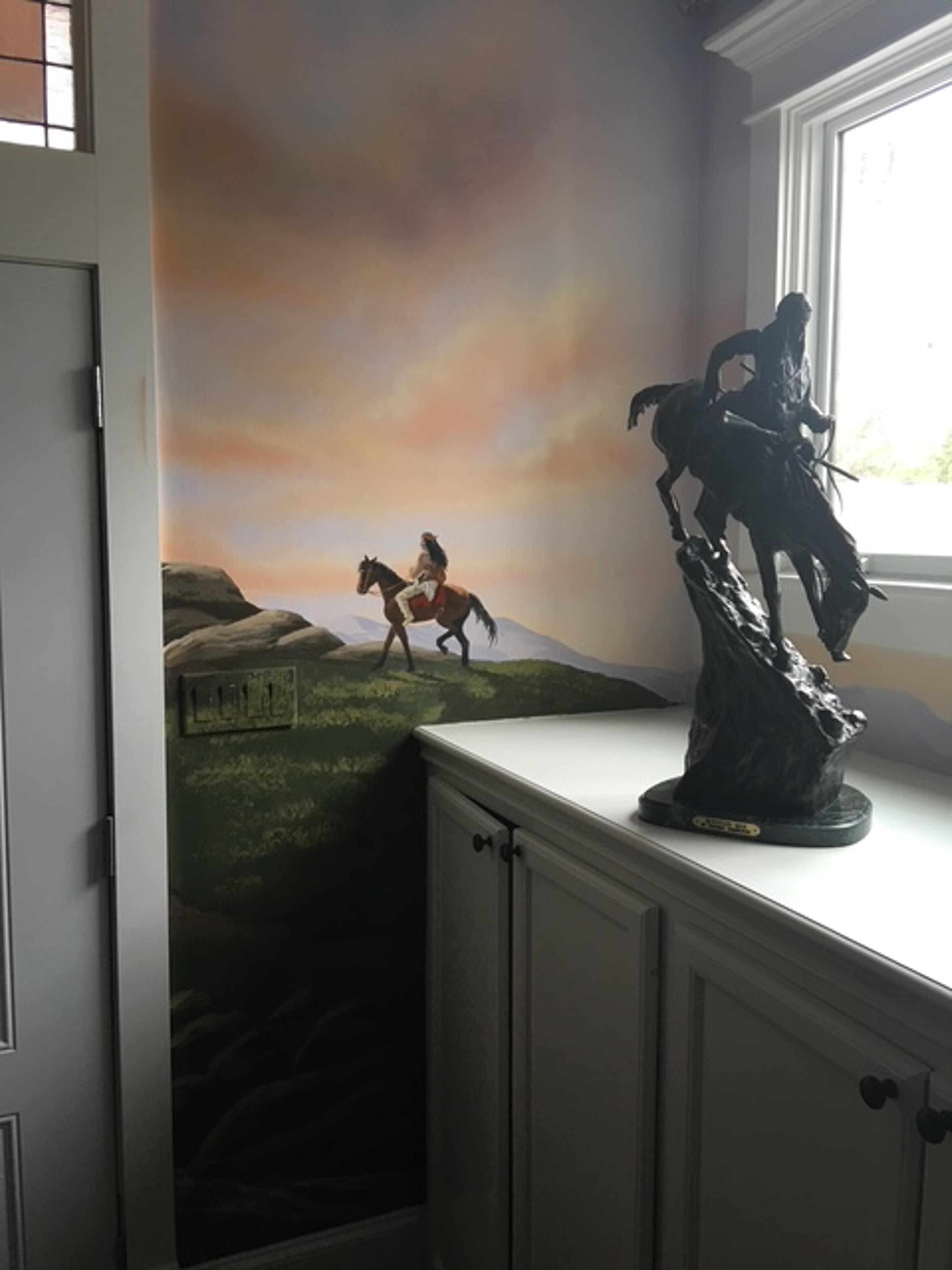 Hand-painted Early American frontier mural in law firm corner with horseback rider and warm sunset sky, Houston TX