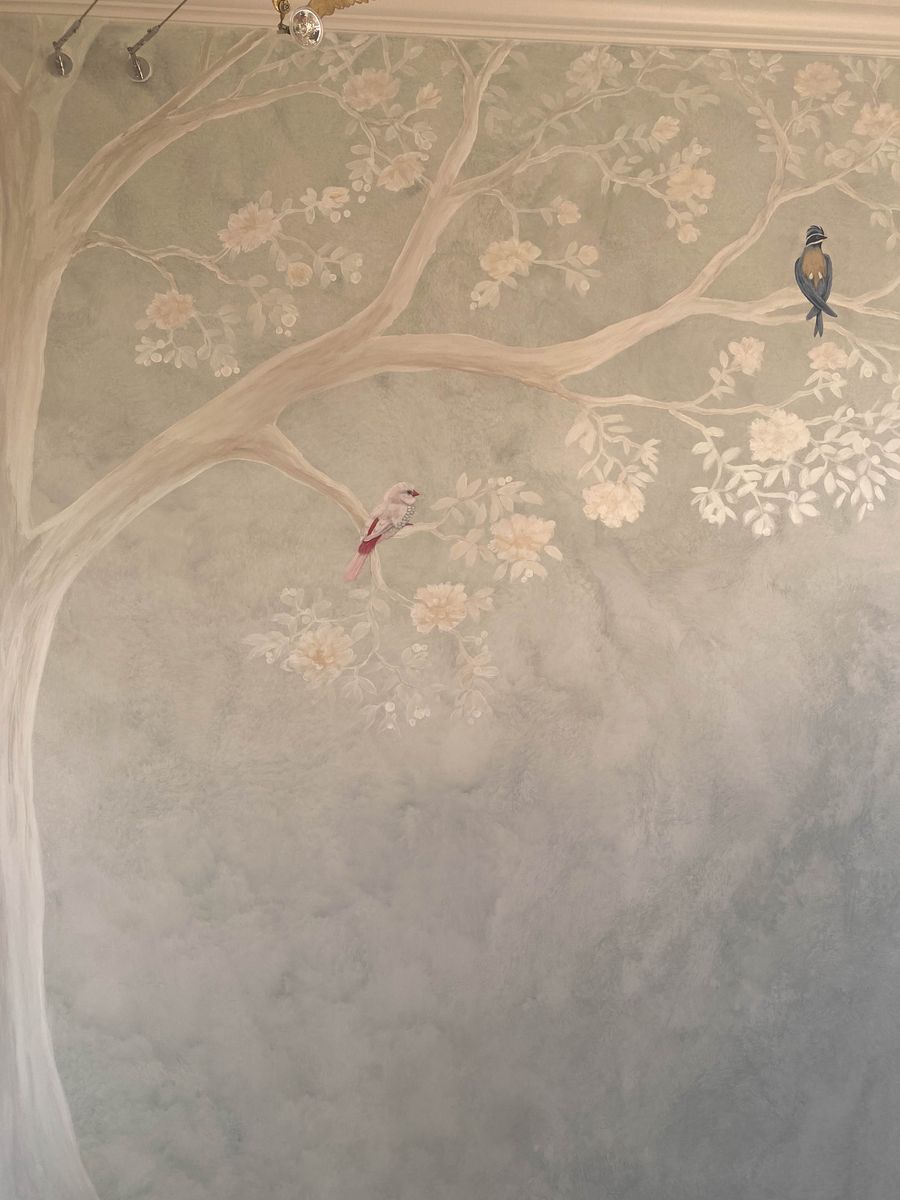Chinoiserie hand-painted mural with sage plaster ground, magnolia tree, white peonies, and perched songbirds on full-height wall