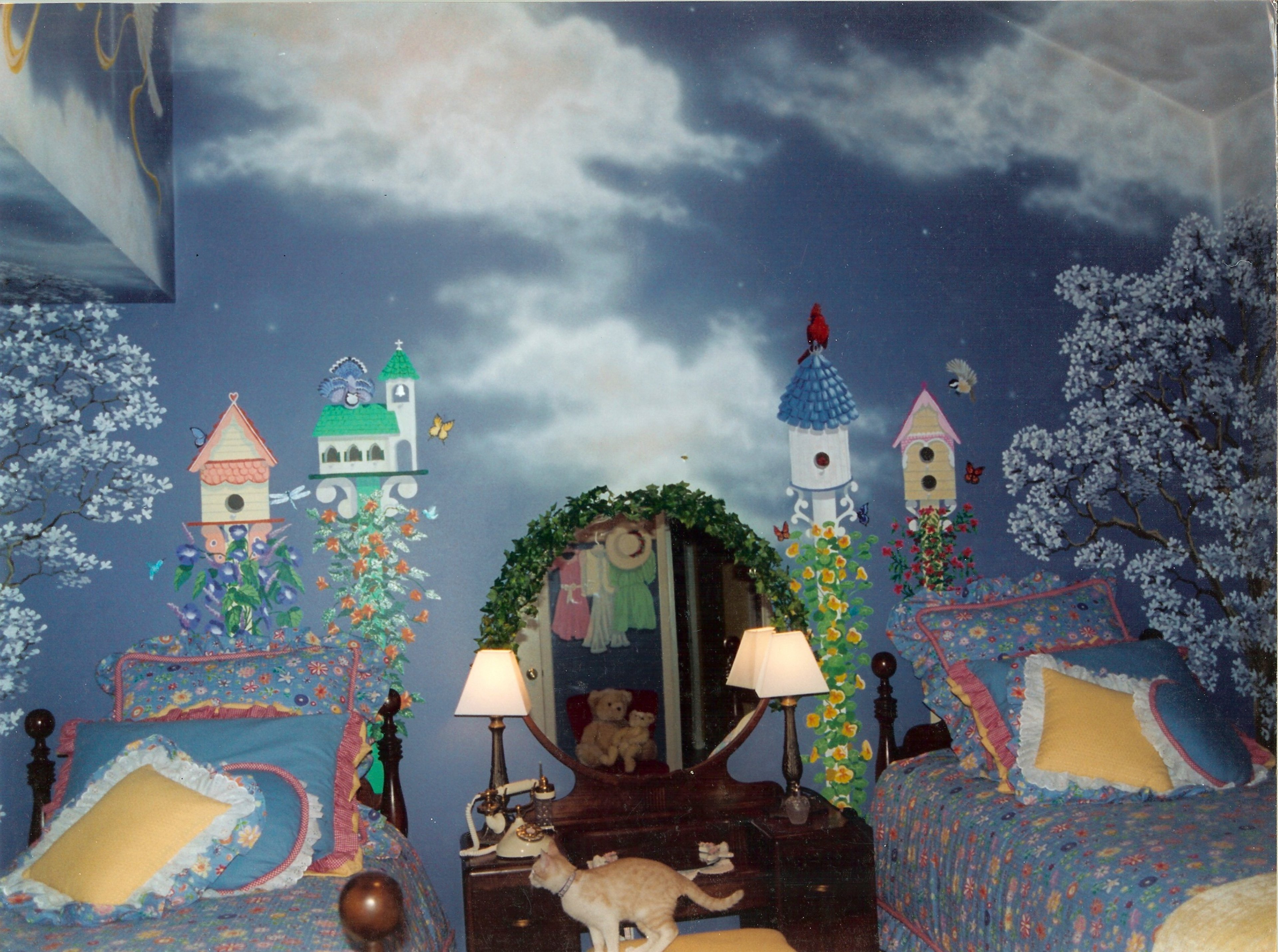 Whimsical hand-painted full-room mural in twin bedroom with night sky, trompe l'oeil birdhouses, flowering vines, and blossom