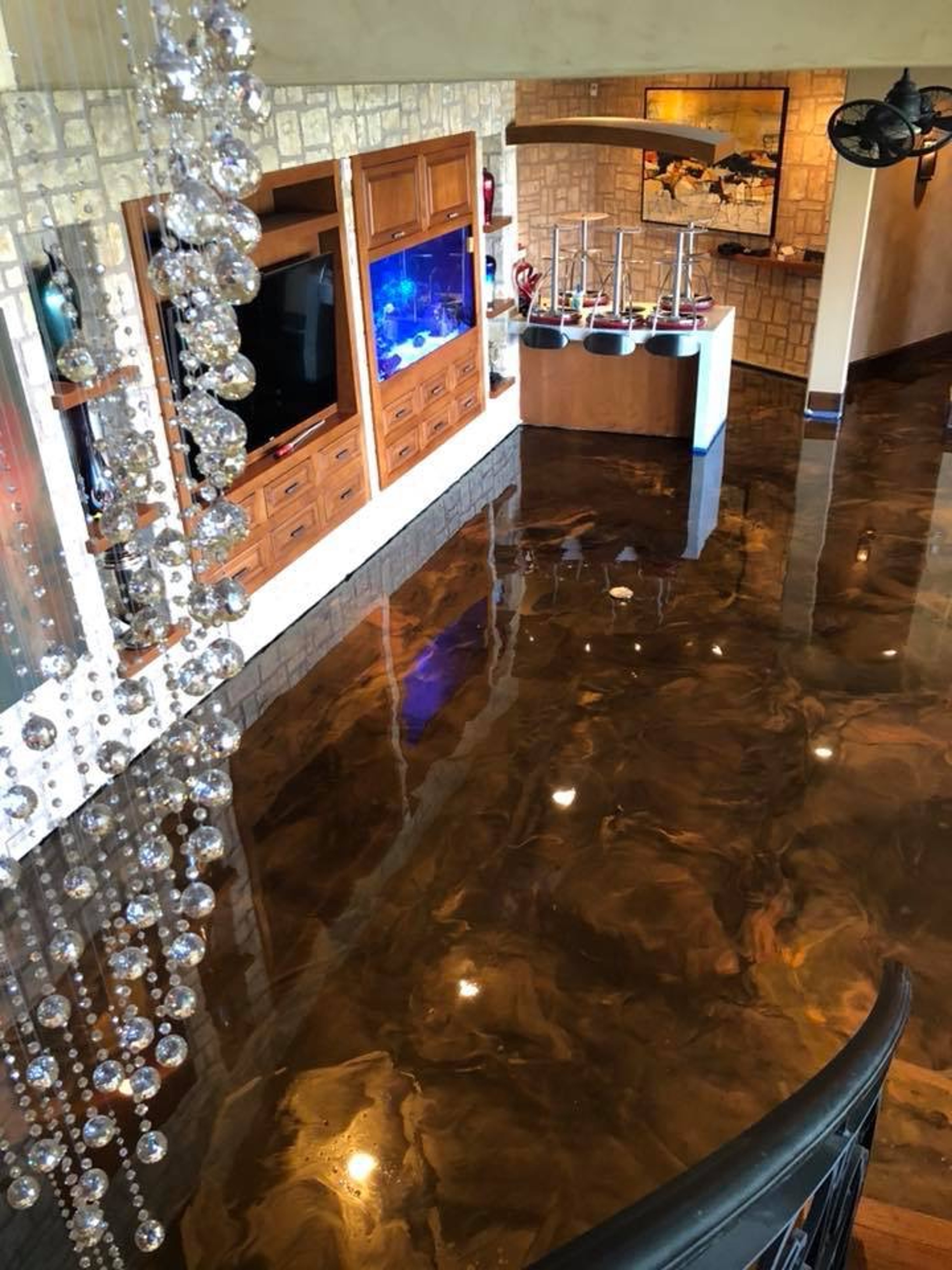 Metallic epoxy floor in great-room with amber and bronze marble swirl pattern and mirror-gloss finish, Houston residential.