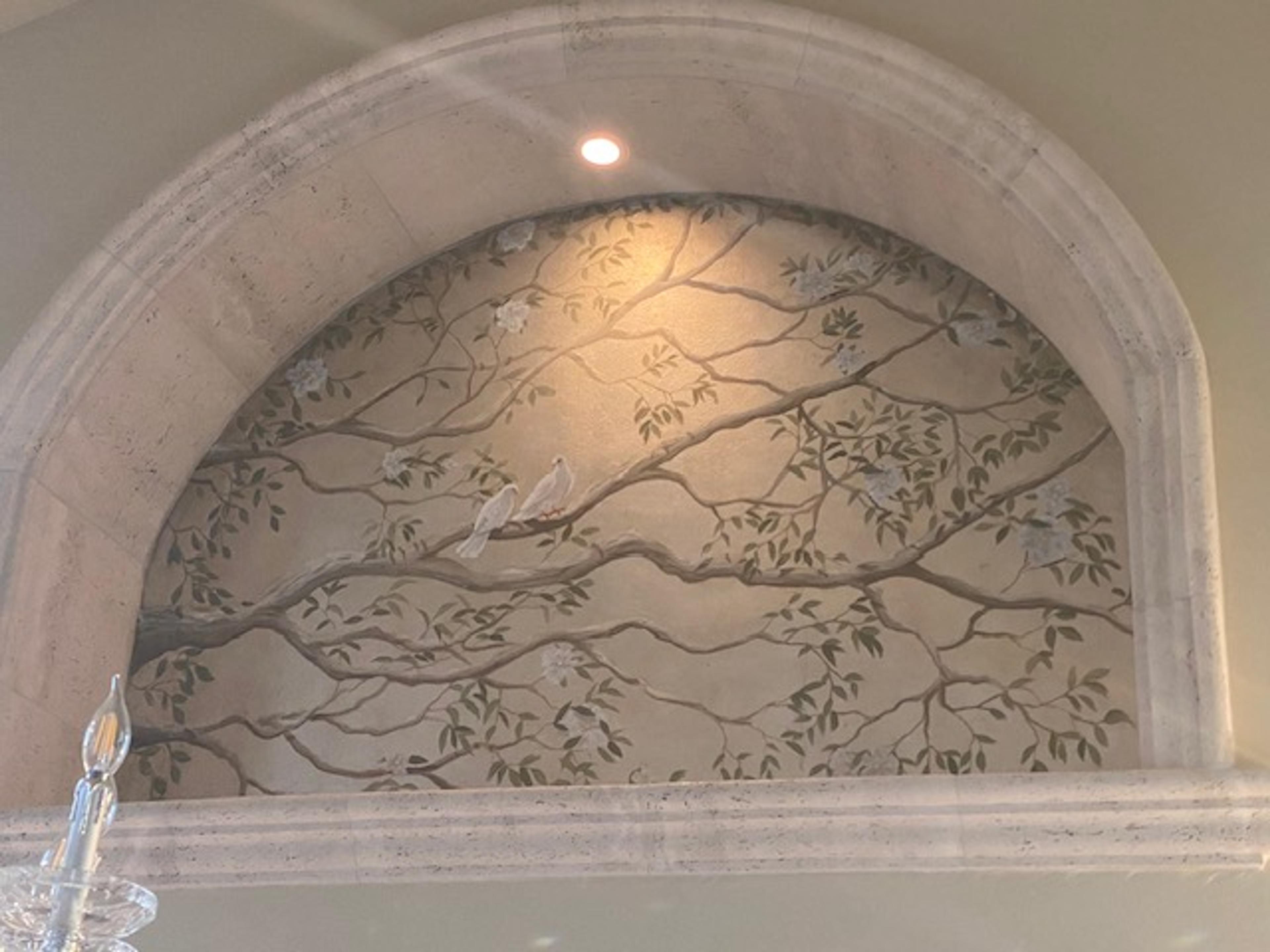 Hand-painted chinoiserie mural in arched stone niche with bird and branch motif, residential interior, neutral tones
