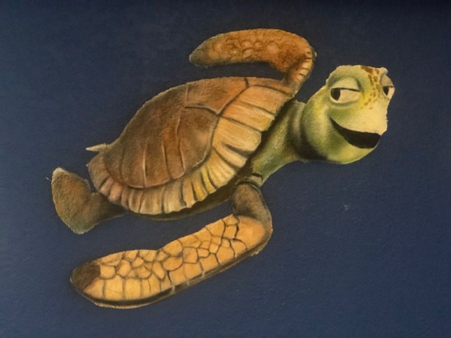 Hand-painted Finding Nemo Squirt sea turtle mural on navy wall, children's room character art by Misha Creations Houston