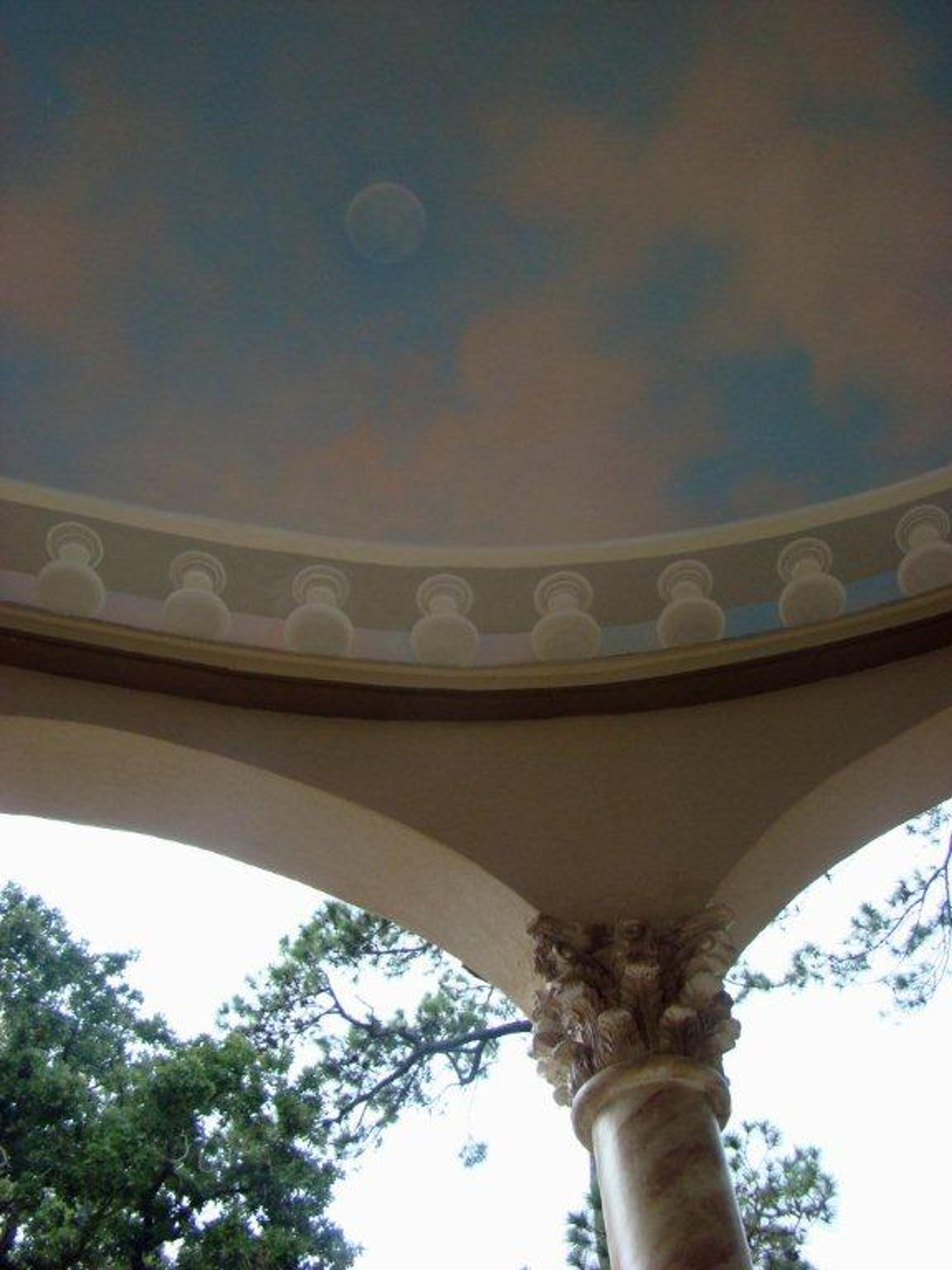 Trompe l'oeil sky mural on domed rotunda ceiling with classical dentil molding and Corinthian column, outdoor loggia
