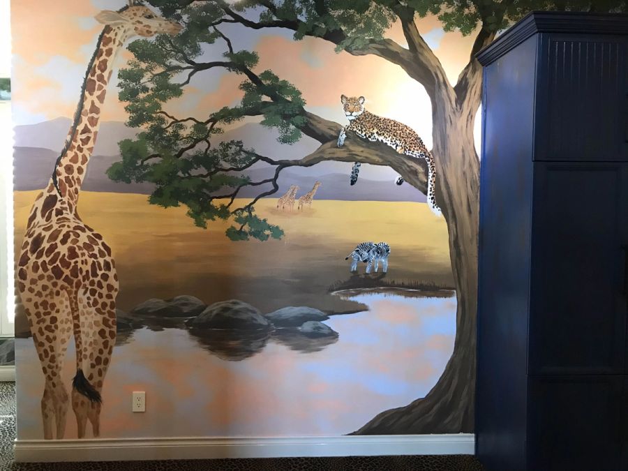 Hand-painted African safari mural in child's bedroom featuring giraffe, leopard in acacia tree, and zebras at watering hole.