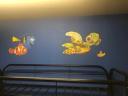 Hand-painted Finding Nemo character mural in children's bedroom with Dory, Nemo, and Squirt on blue wall.