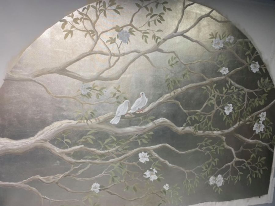 Hand-painted chinoiserie mural with silver-leaf background, white doves on branches with blossoms, arched wall niche