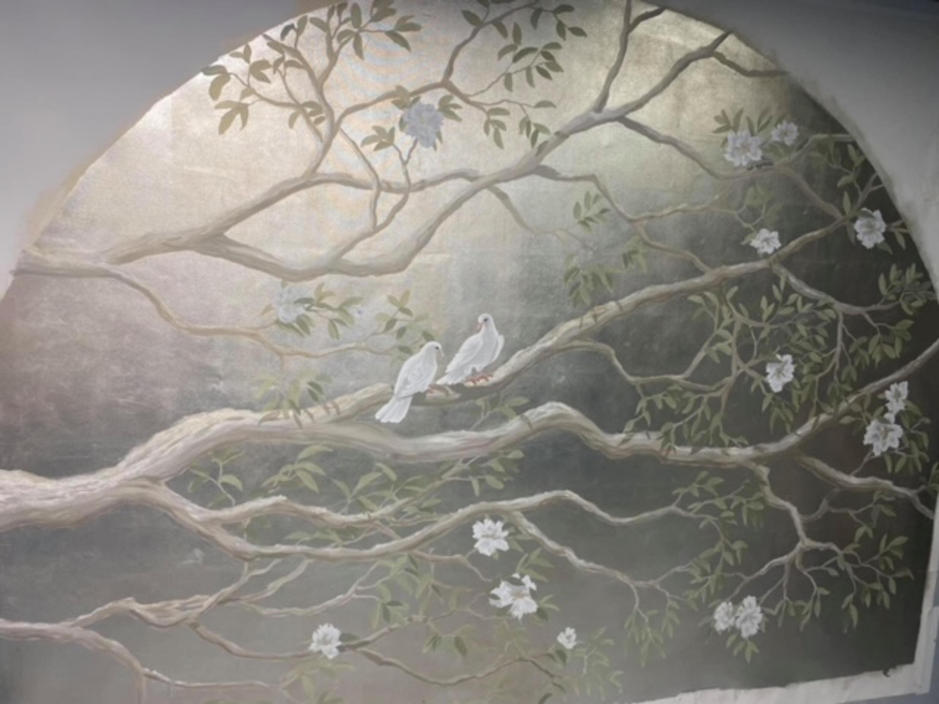 Hand-painted chinoiserie mural with silver-leaf background, white doves on branches with blossoms, arched wall niche