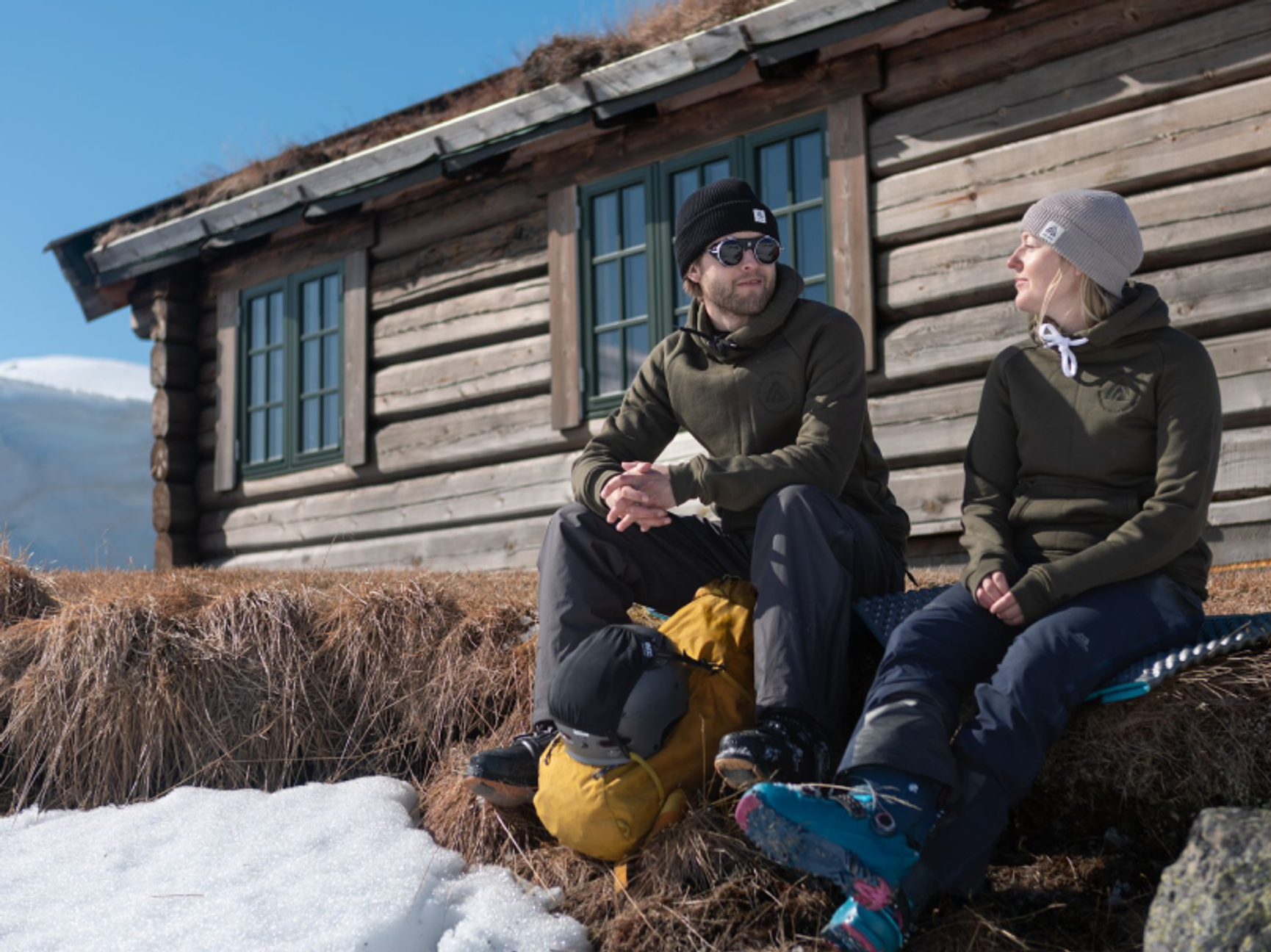 två personer vid en fjällstuga