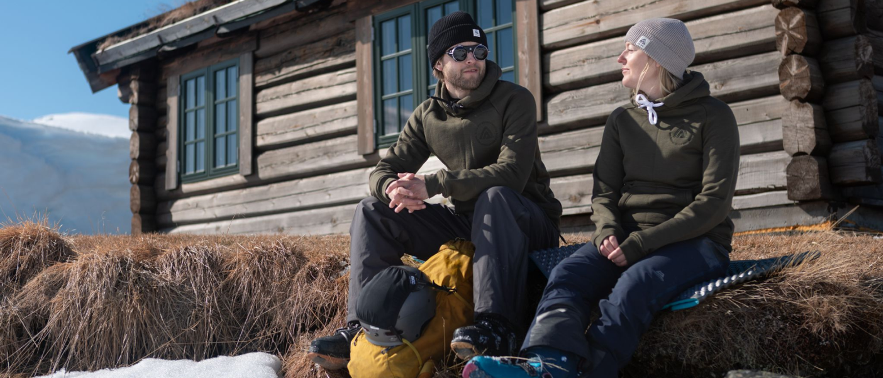 två personer vid en fjällstuga